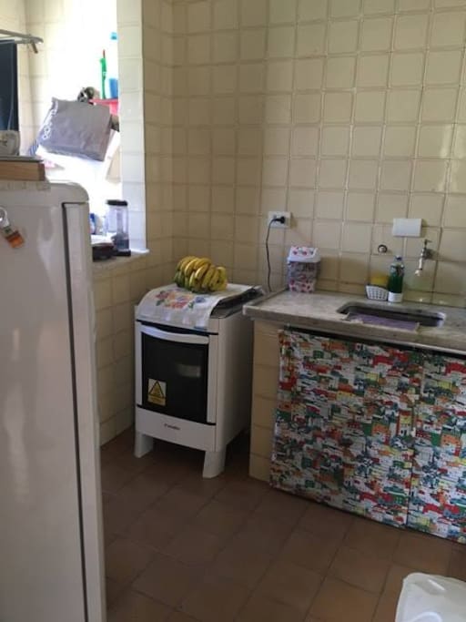 Cozinha pequena , porém suficiente para preparo das refeições. Ao lado, lavanderia com máquina de lavar disponível para uso.