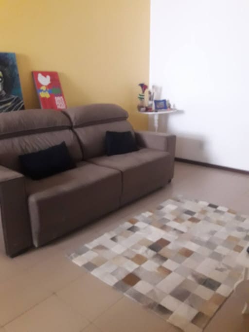 Sala com sofá que acomoda uma pessoa para dormir.