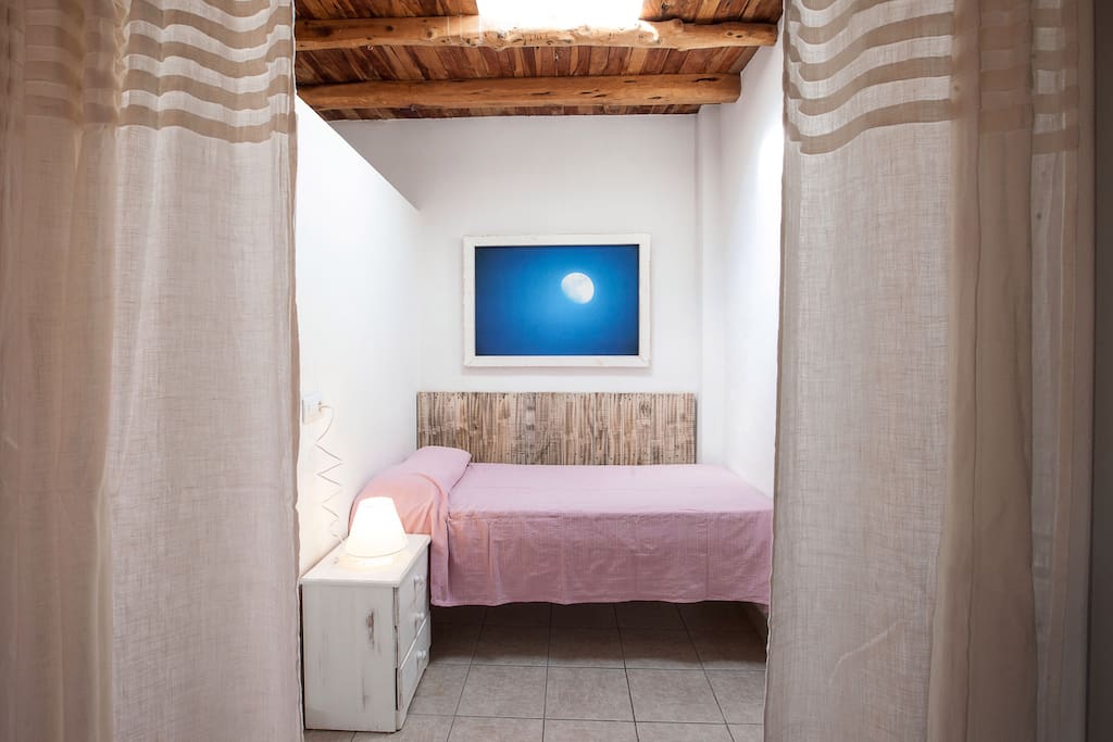 Cama individual. La habitación comunica con la de matrimonio y esta separada de ella por una cortina