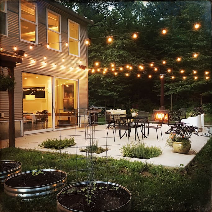 The patio is surrounded by gardens and trees.