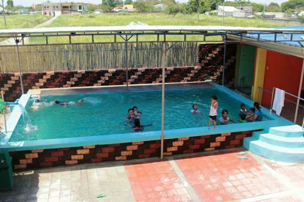 Swimming pool facility infront of 2-storey building (rooms)
