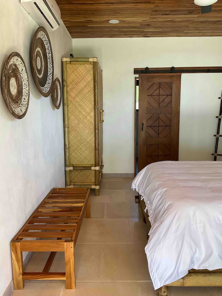second bedroom with native bamboo queen bed, bamboo wardrobe, safe, en suite full bathroom