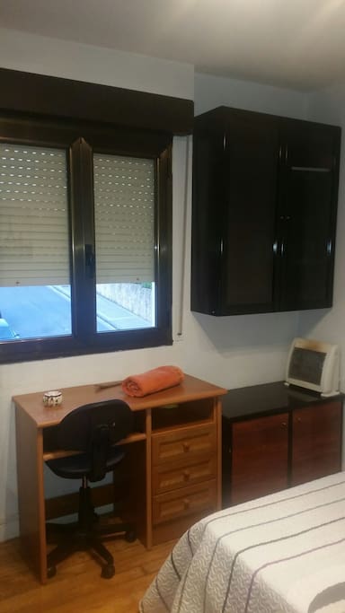 escritorio con silla y dos armarios para guardar la ropa