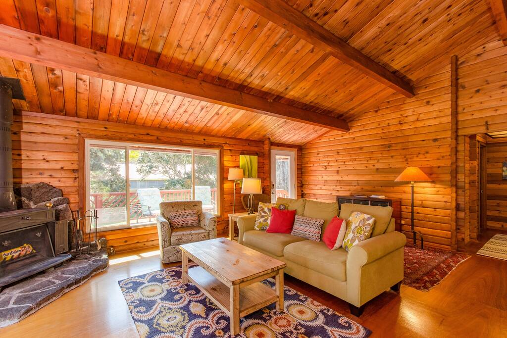High ceilings, a wood burning stove and lots of windows highlight the open concept living and dining area