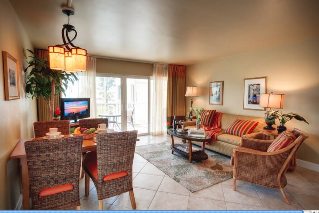 Picture of the living room and dining area. Will have: table for four, arm chair, couch, HD TV, coffee table, desk and chair.