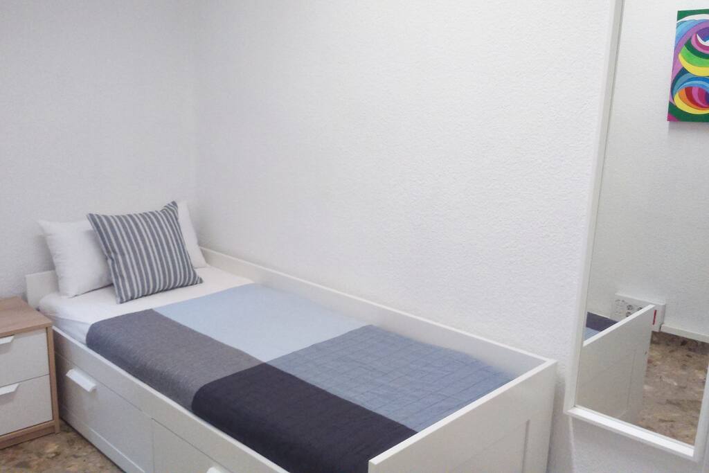 Habitación 2. Cama individual (1,25) con espacio de almacenaje, mesita de noche, espejo de cuerpo entero, armario, televisión, escritorio + aire acondicionado.