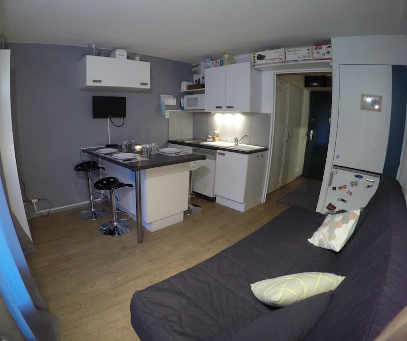 Séjour avec canapé convertible (BZ), porte-fenêtre donnant sur le balcon et coin repas