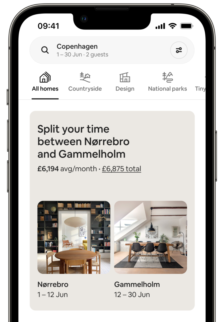 The screen of a mobile phone shows a Split Stay. The screen says: “Split your time between Norrebro and Gammelholm” and displays the price for the trip. Below, there are two photos of the homes. The Norrebro image shows a dining room with a large charcoal bookcase and a modern pendant light. The Gammelholm image shows another dining room, this one lit by a large skylight. Each photo is captioned with dates, which make clear that the guest would spend 12 days in Norrebro, followed by 18 days in the Gammelholm home.