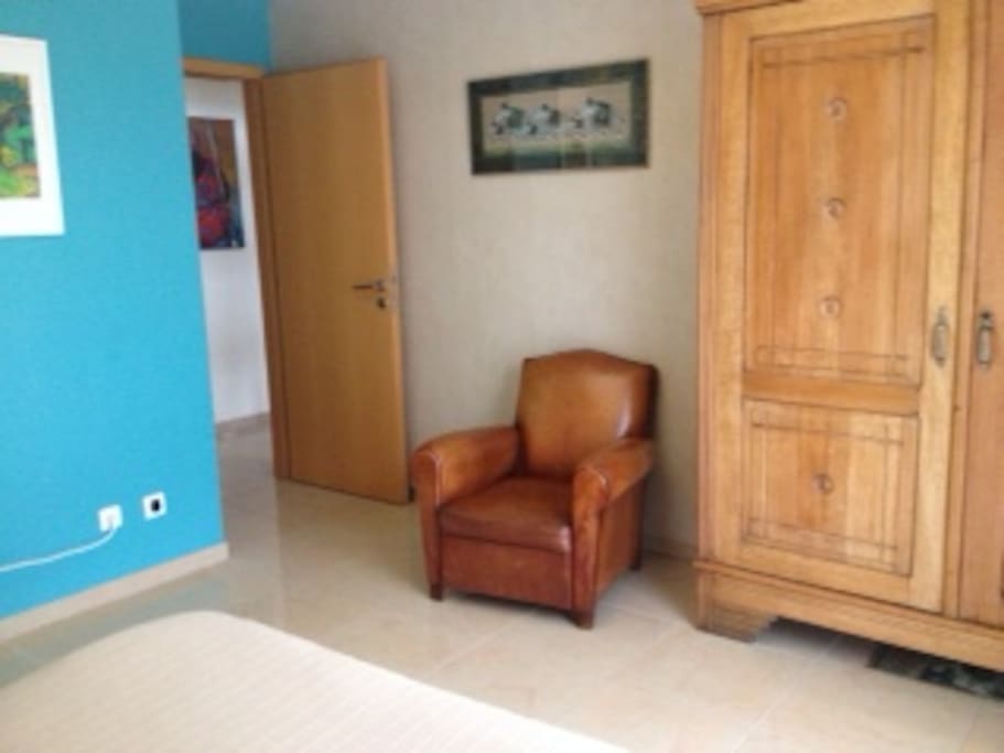un fauteuil et une armoire à disposition dans la chambre