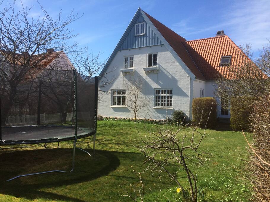 huset set fra forhaven med gynge og stor trampolin