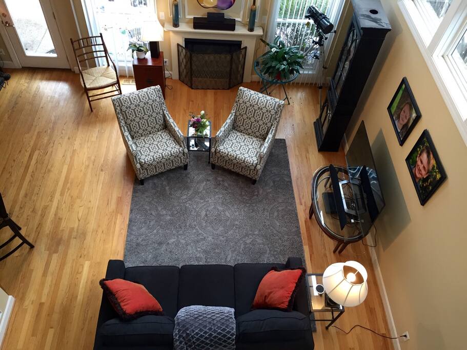 Bright and airy living room with vaulted ceiling, large windows, gas fireplace, wireless internet and Bluetooth speakers, smart tv with Netflix, Amazon prime, and cable, and comfortable sofa for additional sleeping.