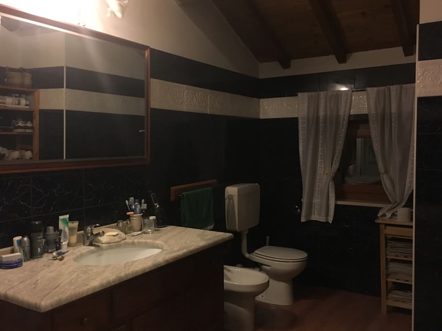 Elegante e spazioso Bagno in marmo blu e parquet. Elegant bathroom in blue marble.