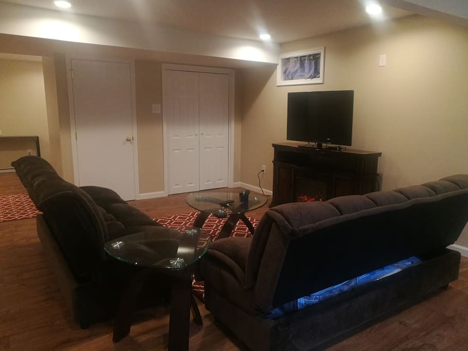 Private living room with two sofa sleepers and fireplace entertainment center with roomy closet and pantry in the background.