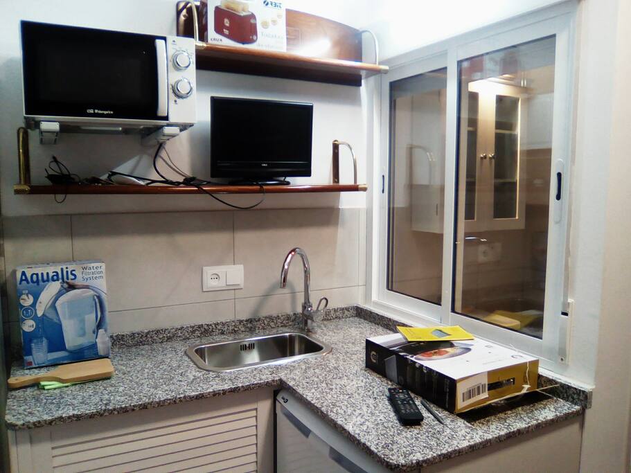 Cocina, fregadero, microondas, armario y nevera.