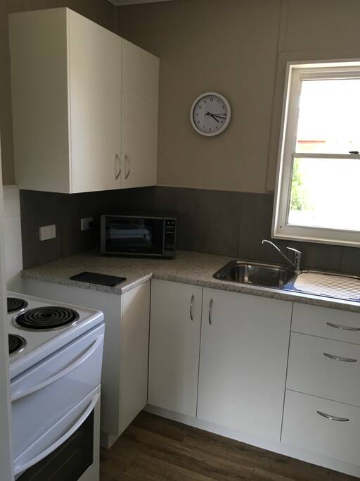 Full kitchen including fridge, microwave and utensils.
