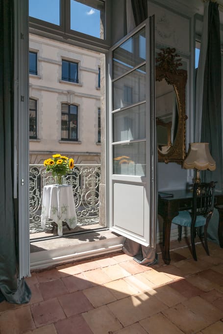 Romantic decor on a French balcony of an apartment with terracotta tile and French doors. Versailles style furnishings and luxurious architecture paint a picture of South of France charm. #france #apartment #french #Paris #balcony