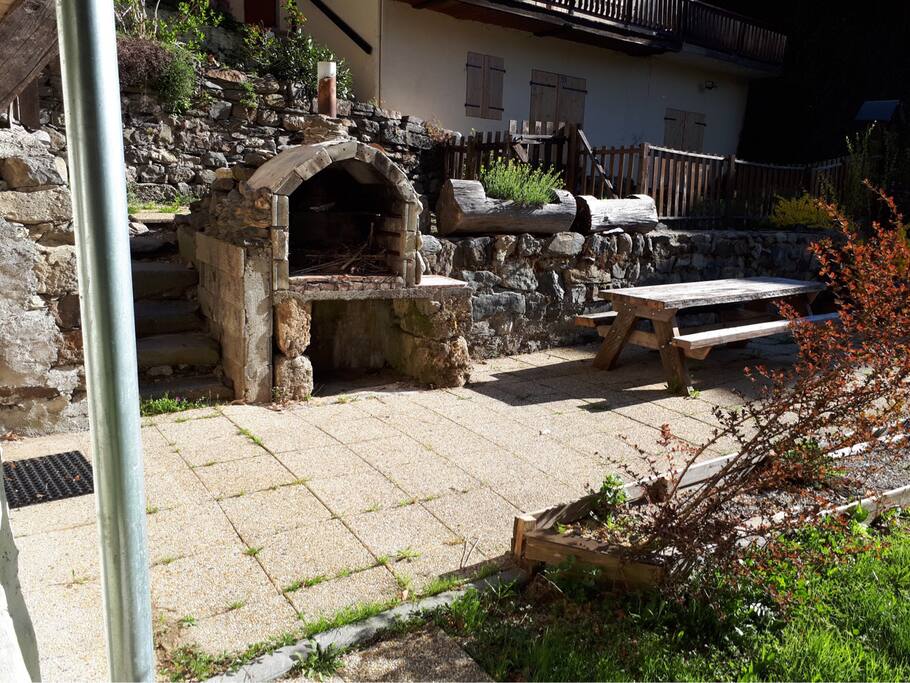 Terrasse avec barbecue en pierre et table de jardin