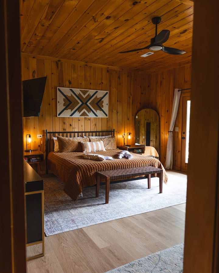 Spacious lower-level master suite designed for comfort, privacy, and relaxation. Featuring a plush king bed, this quiet cabin retreat includes a Roku TV, dresser, closet, futon, and reading chair - everything you need for a restful and convenient sta