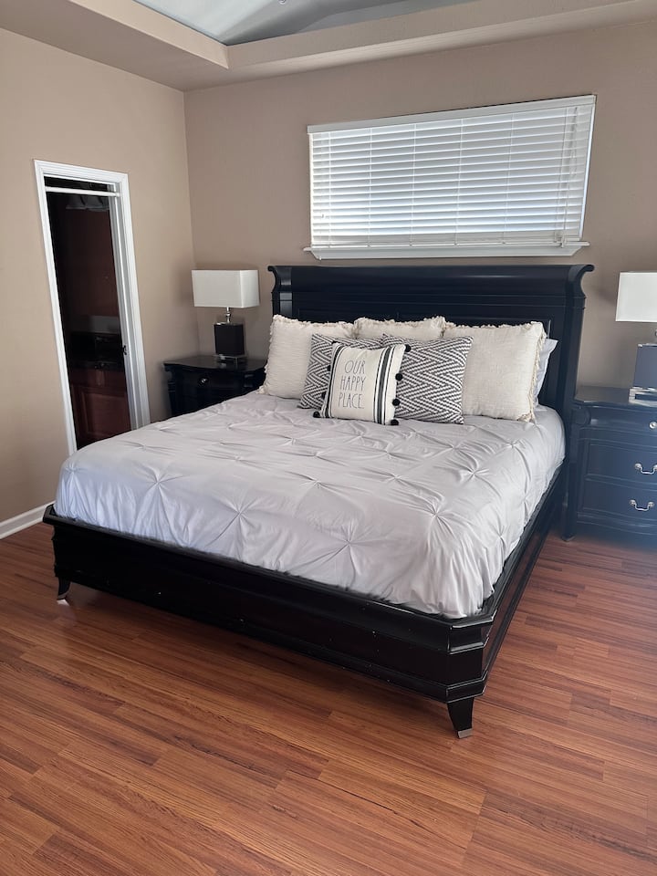 Un élément clé est le lit king size, offrant beaucoup d'espace pour une nuit de sommeil confortable. Un placard et une grande commode fournissent des solutions de rangement pour les vêtements et les objets personnels, aidant à garder la pièce organisée et sans encombrement.