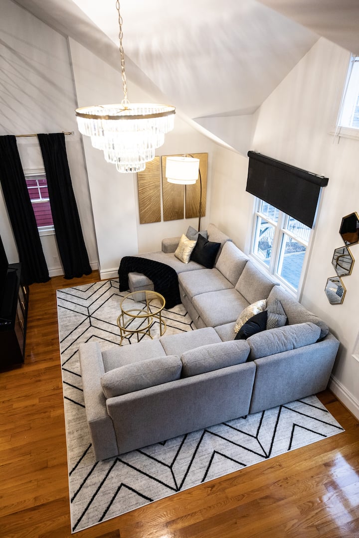 This is a living room on the second floor. 65in Roku TV with guest mode activated so you can log into any of your streaming apps. Relax on this large sectional which also features a pop-out bed. Use it as an extra bed or a huge ottoman for lounging!