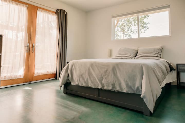 Habitación sencilla y limpia con una cama queen.