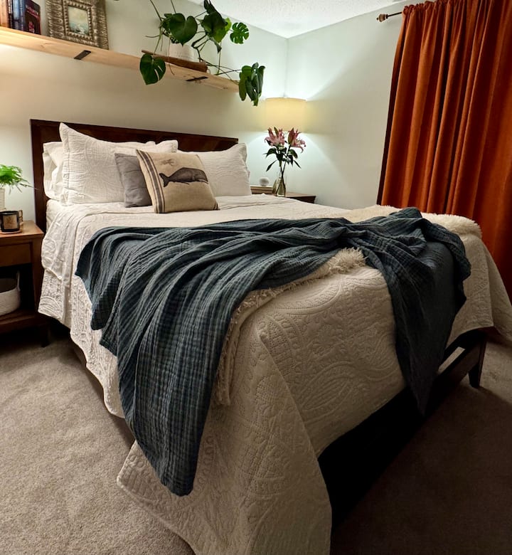 Bedroom #1-Primary Queen bed with attached full bathroom and side chair.