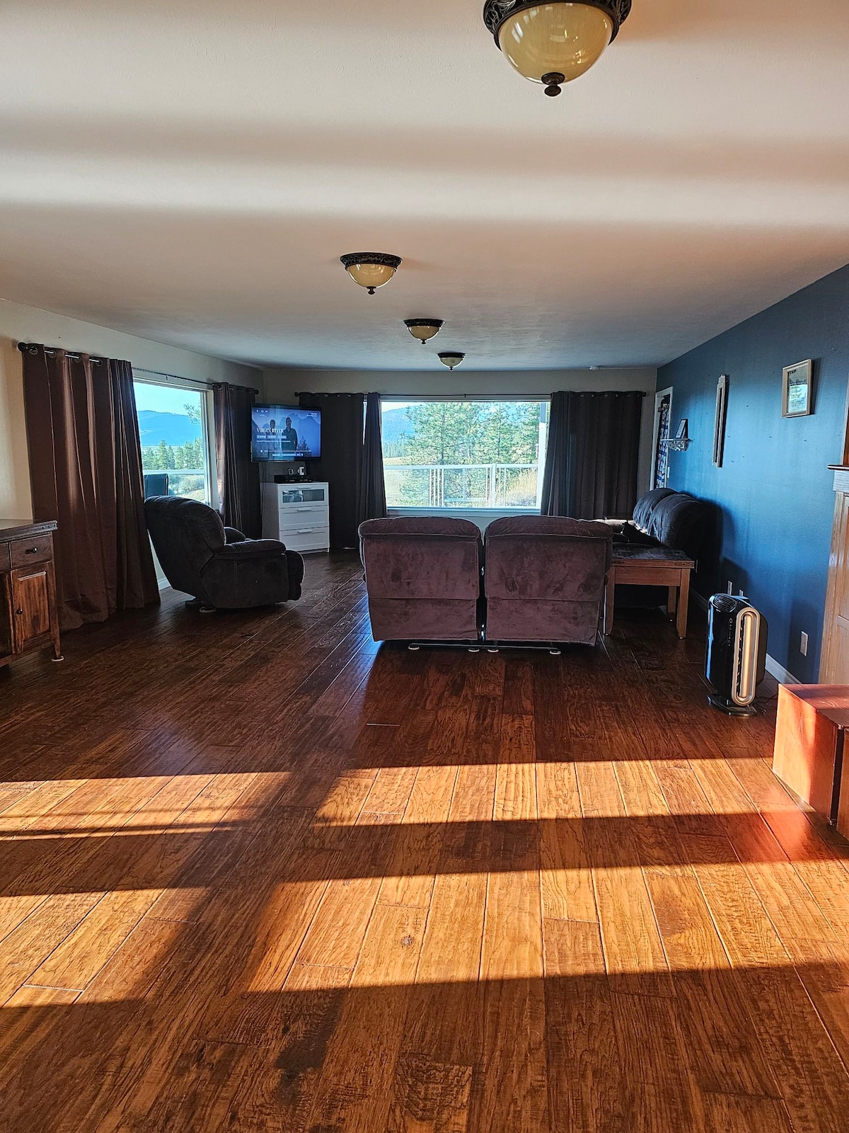 dhomë ndenjjeje e madhe me divan, ndenjëse dashurie dhe roker.