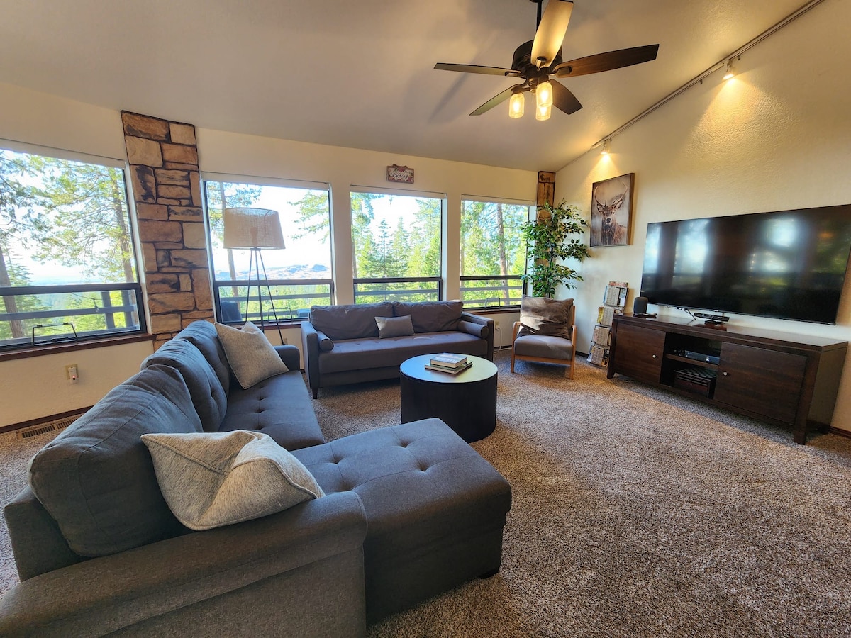 Una acogedora sala de estar con grandes ventanales que traen la belleza de la naturaleza al interior, perfecta para relajarse y disfrutar del amanecer y el atardecer. 