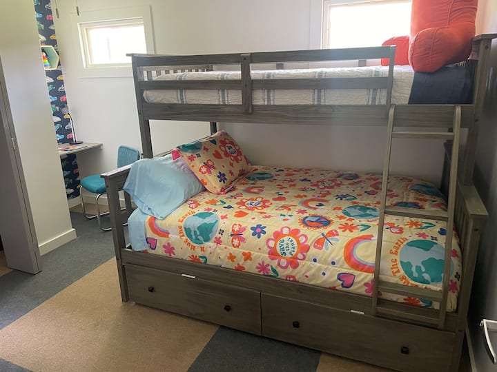 This bedroom sleeps three. It has a bunk bed with a double bed on bottom and twin on top. 
There is a desk and a leather topped two drawer chest for your suitcase. 
For kids there are books, toys and a pack-n-play located in a drawer under the bed. 