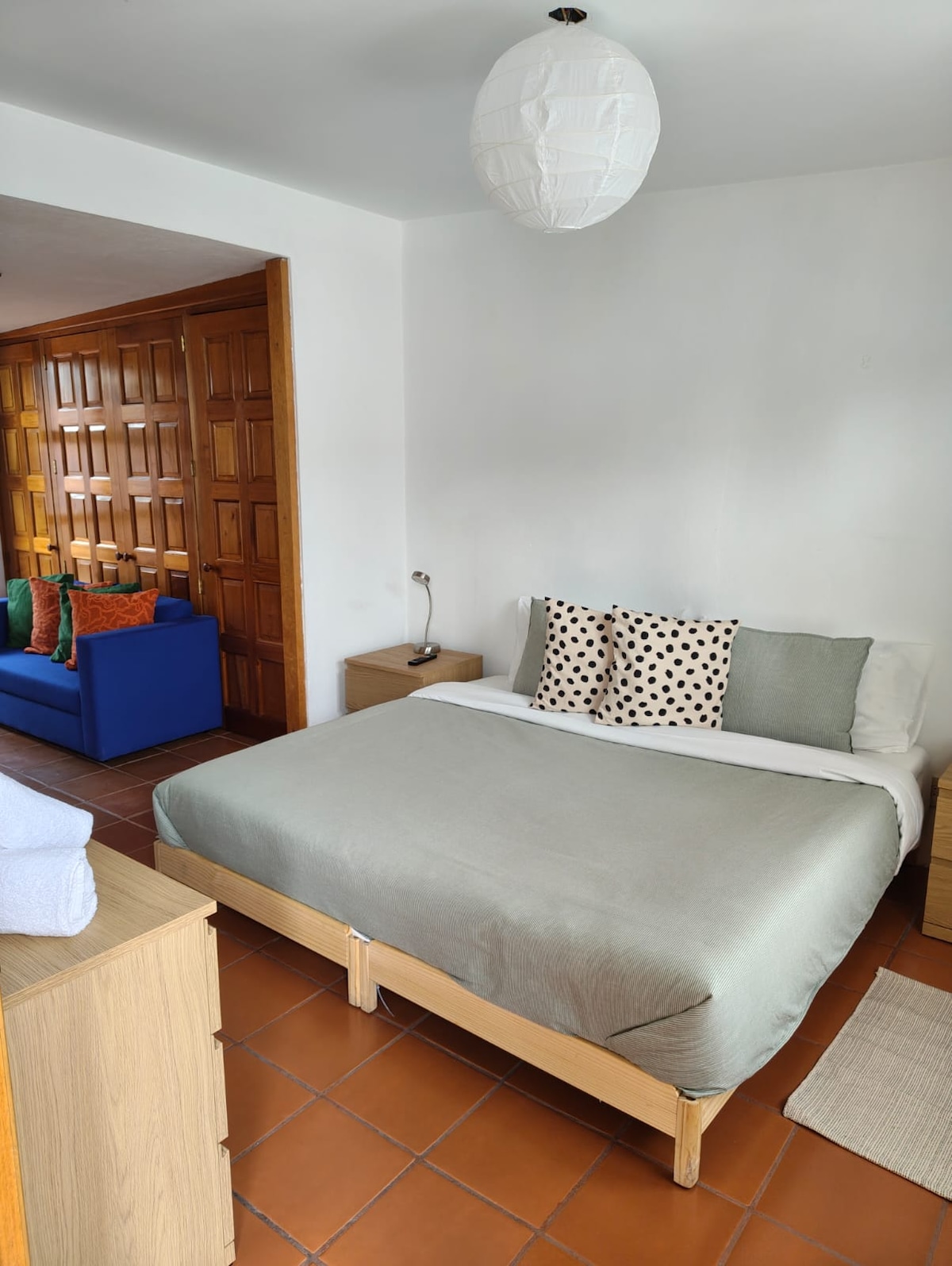 Спалня с голямо двойно легло и тъмни завеси за пълна тъмнина.