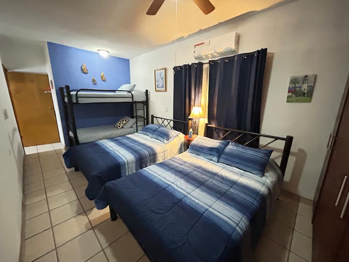 Საძინებელი ისეთივე ლურჯია, როგორც ზღვა ფარდებით, რომელიც მუქდება და გიწვევთ დასასვენებლად და დასაძინებლად დროის ნებისმიერ მონაკვეთში. 
*2 ორადგილიანი საწოლი, *1 ორსართულიანი საწოლი (2 ერთადგილიანი)
*A/C, ჭერის ვენტილატორი, Wi-Fi 281
*კარადა საბნებითა და პატარა ორენოვანი ბიბლიოთეკით.