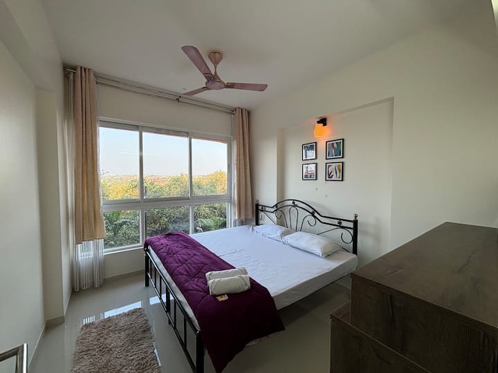 تتميز غرفة النوم بسرير متوسط الحجم ونافذة كبيرة توفر إطلالة خلابة على المساحات الخضراء المورقة، مما يخلق جوًا هادئًا وطبيعيًا. إنه المسكن المثالي للاسترخاء والتواصل مع الطبيعة.