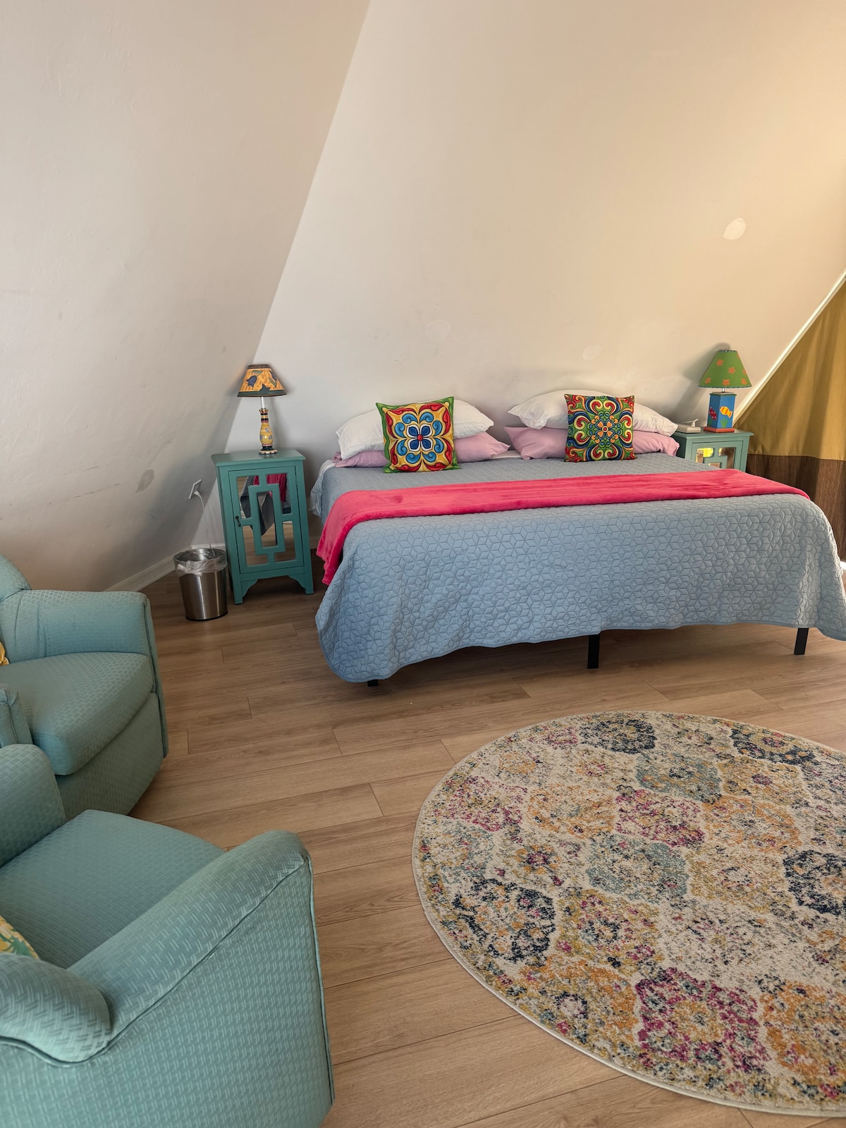 upstairs bedroom with king bed, seating area, TV