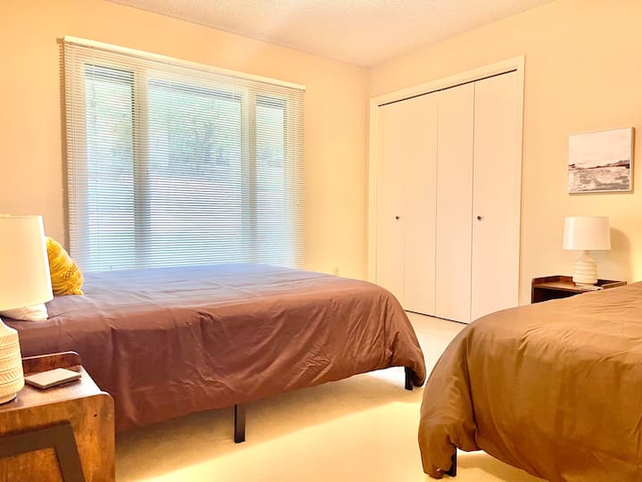 חדר שינה לאורחים בקומה הראשית עם מיטת קווין סייז אחת ומיטת זוגית אחת.