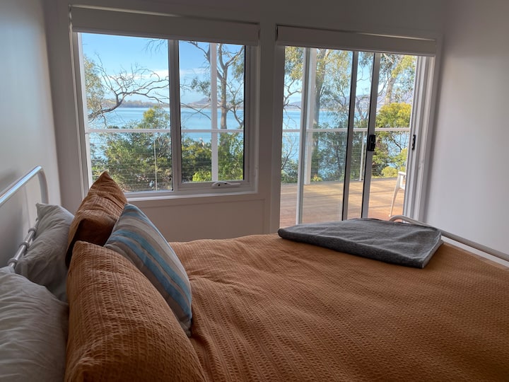 Спална соба 1 - поглед од креветот со врата кон пространата тераса. Поставен е тавански вентилатор. 