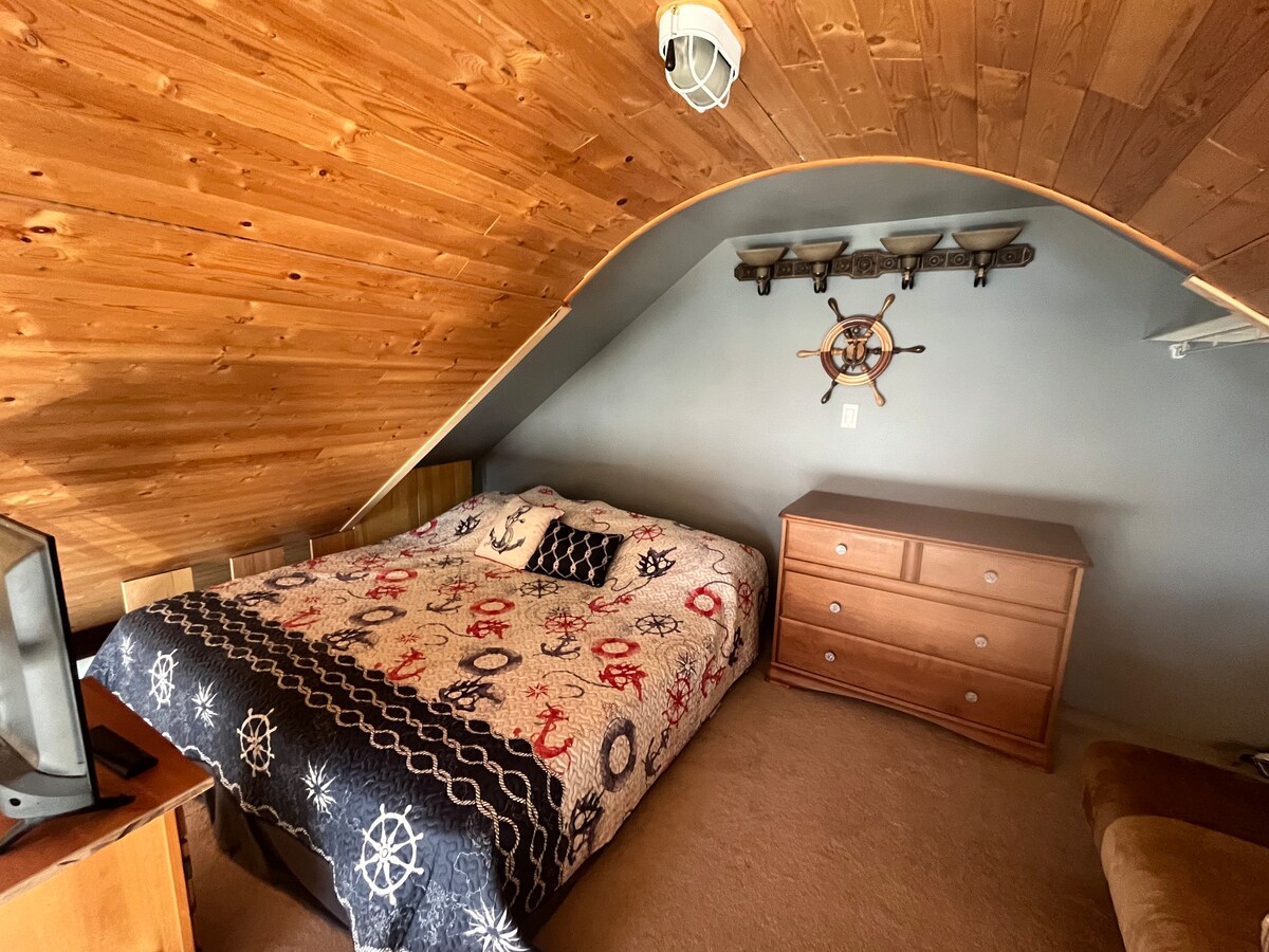 Ლოფტის საძინებელი დიდი ზომის საწოლით.