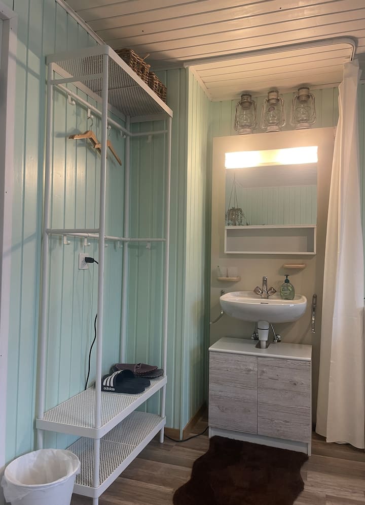 In de kamer heeft het een wastafel en een kledingkast met hangers. De bestaande vinken kunnen worden gebruikt voor de mars naar de badkamer:-) Er is ook een badjas achter de deur.