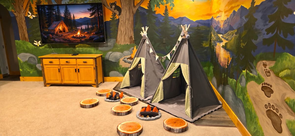 Bigfoot Bunk Room – camp-themed kids' room with teepees and a forest mural