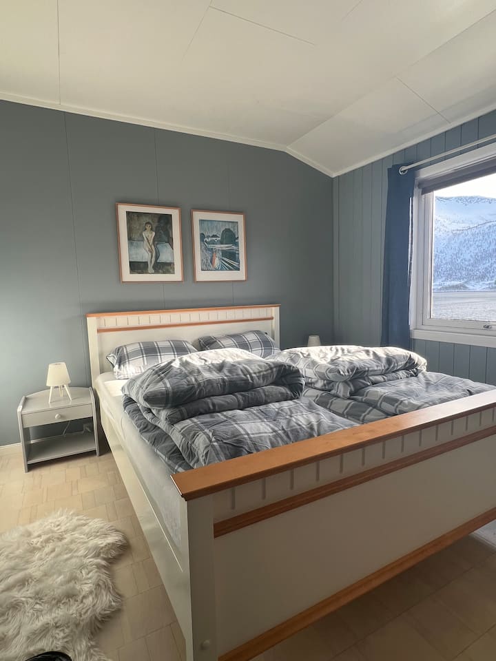 Hlavná spálňa má priestrannú manželskú posteľ, dostatok priestoru v skrini a fantastický výhľad na fjord.