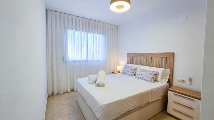 Cama de 150x190, dos mesillas, armario empotrado, aire acondicionado, ventilador de techo y un baño en suite