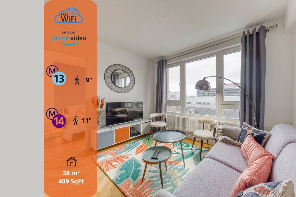 A modern living area features a comfortable sofa complemented by a decorative rug. Large windows allow natural light to fill the space, enhanced by fresh curtains. A television is positioned upon a stylish media console, with two small tables providing additional surface area.