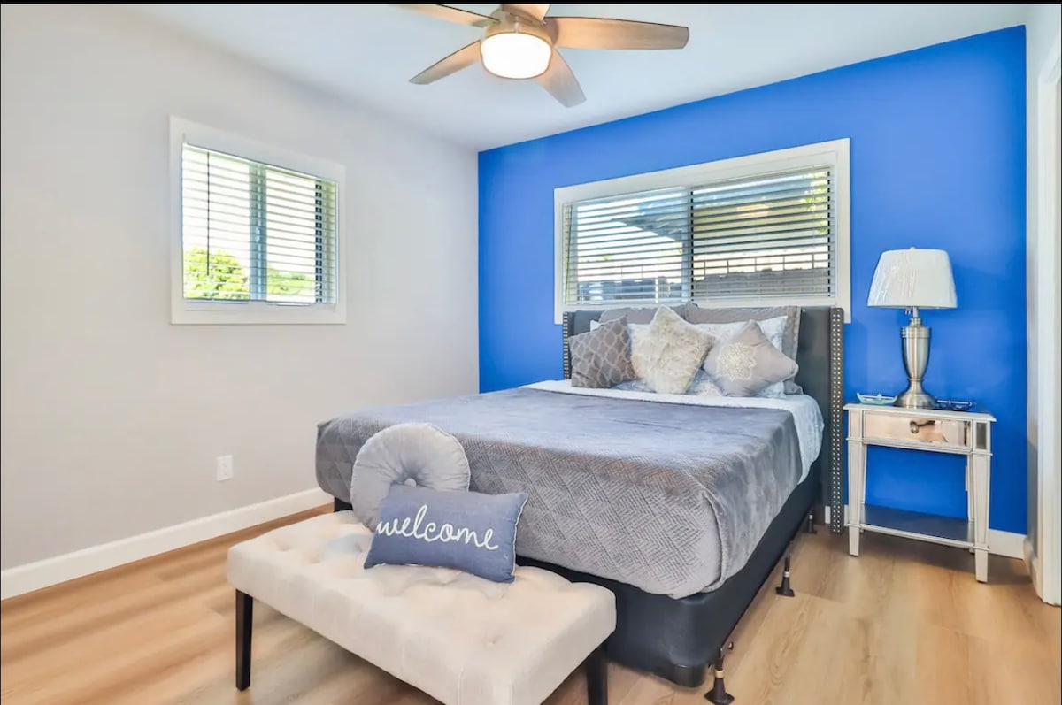 Acogedor dormitorio con pared azul y almohada de bienvenida