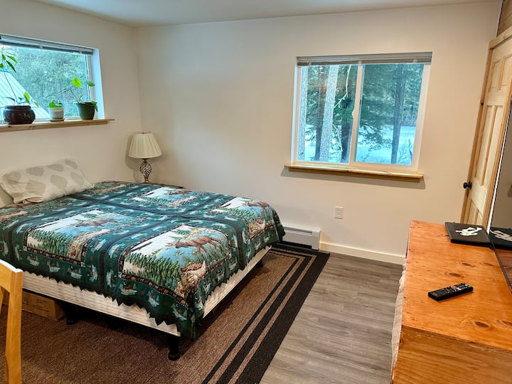 Otvorená obývacia izba s manželskou posteľou. Inteligentná 55-palcová televízia.