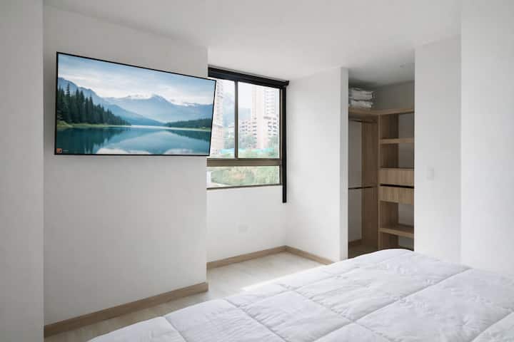 ダブルベッド、大型テレビ、広々とした窓が快適な景色で空間を照らす客室。クローゼットはオープンタイプで、整理整頓しやすくなっています。快適で機能的な空間でお休みください。


