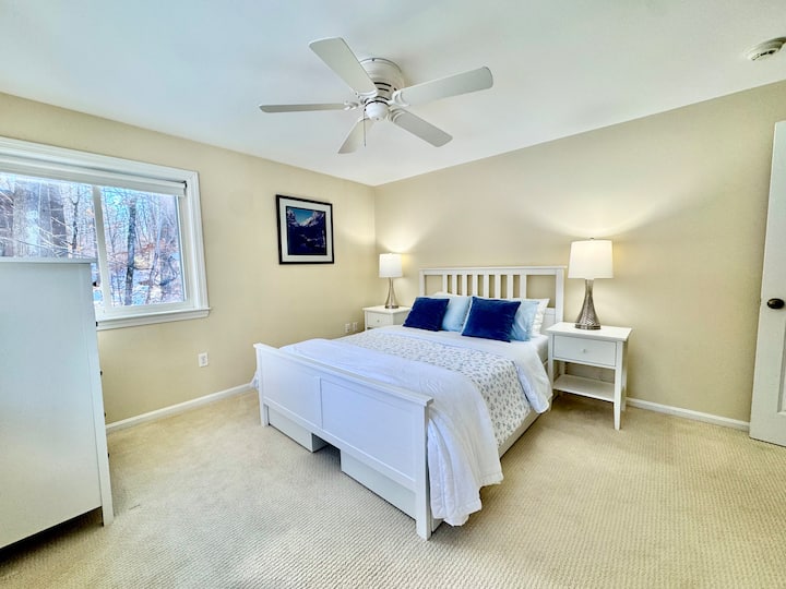 ห้องนอนควีนไซส์ที่อบอุ่นนี้มีที่นอนเมมโมรี่โฟมใหม่ สีโทนกลางที่นุ่มนวล และวิวป่าที่สงบ มีโต๊ะเครื่องแป้ง ตู้เสื้อผ้าพร้อมไม้แขวนเสื้อและผ้าห่มเสริม และใช้ห้องน้ำเต็มรูปแบบขนาดใหญ่ (อ่างอาบน้ำเต็มรูปแบบ 2) ร่วมกับห้องนอน 1