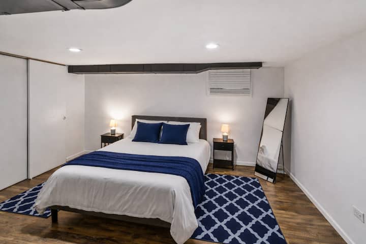 Dormitorio moderno en el sótano con detalles en azul marino