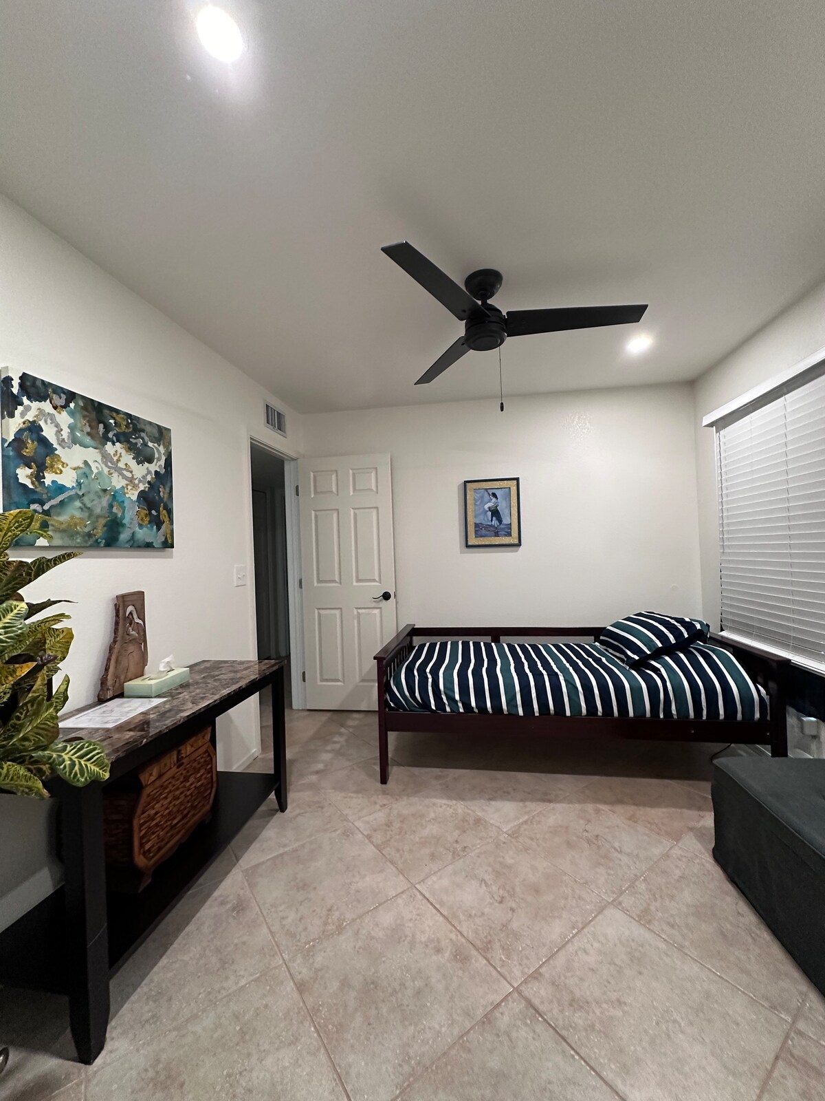 Dormitorio en el nivel inferior con área de escritorio y cama de bacalao/otomana justo al lado del baño completo de los huéspedes con ducha