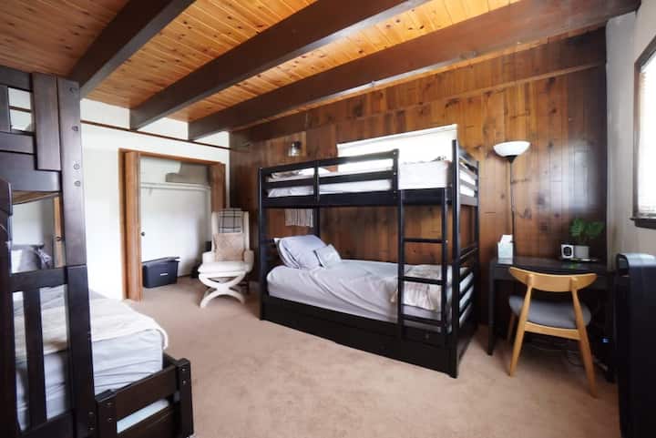 这间卧室配有两张双层床，体验舒适。 全尺寸底层双层床可供放松，配备双人床，让您感受到一丝奇思妙想。 专用工作站允许笔记本电脑工作、阅读或其他悠闲的追求。