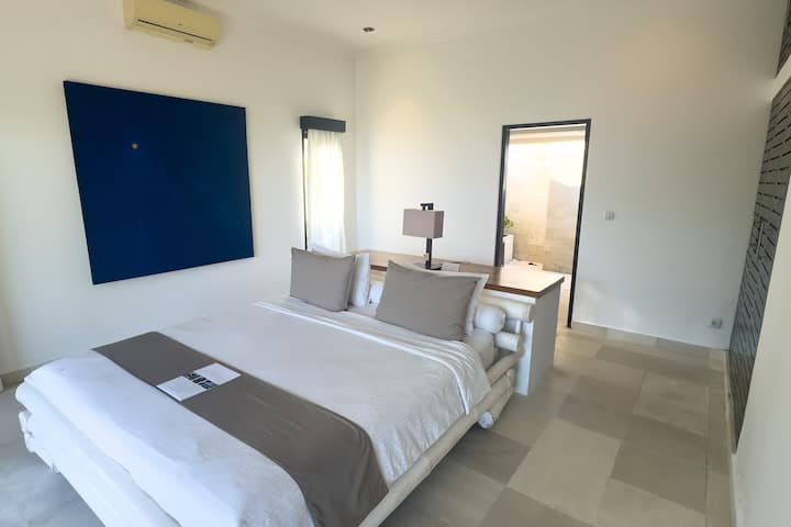A bright, spacious bedroom designed for comfort and ease. The king-size bed, calm tones and direct connection to the ensuite bathroom create a natural, effortless flow for a relaxed and private stay.