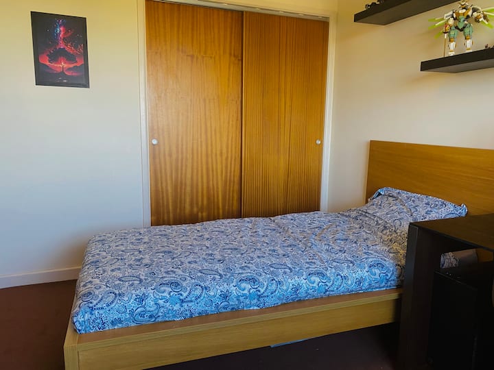 Spavaća soba s krevetom za jednu osobu, radnim stolom i umivaonikom